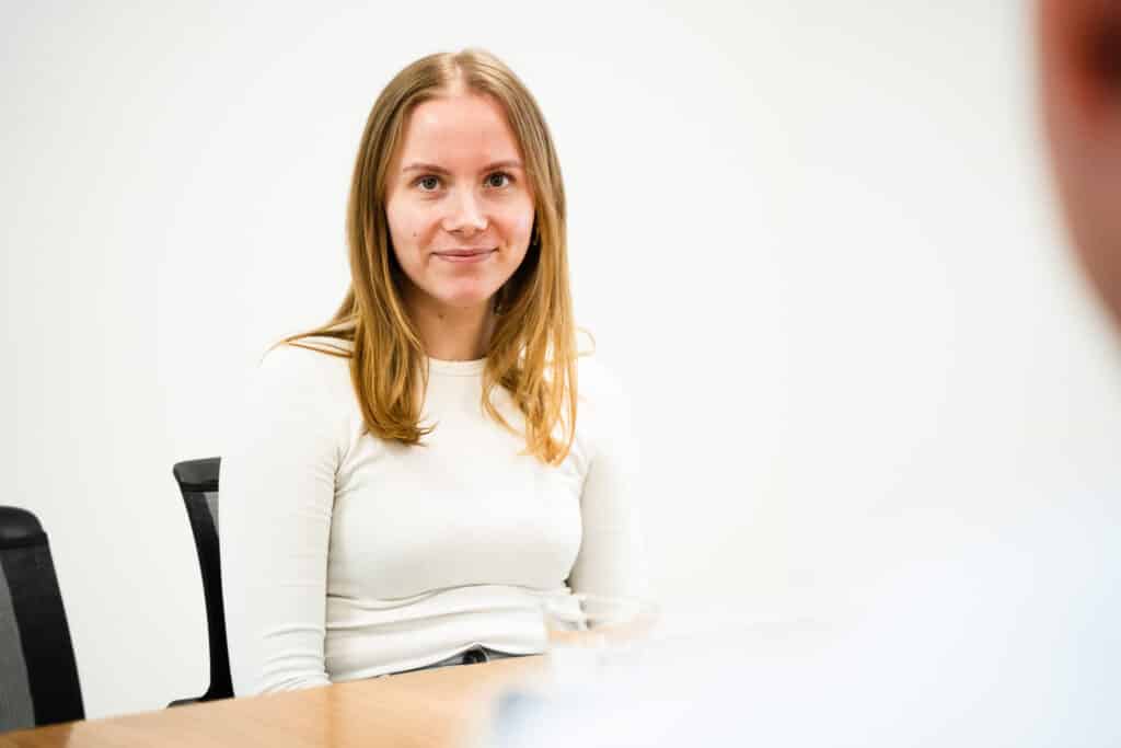 Eine junge Mitarbeiterin bei BAUER während eines professionellen Gesprächs, verdeutlicht das individuelle Wachstum und die Förderung durch das Unternehmen.